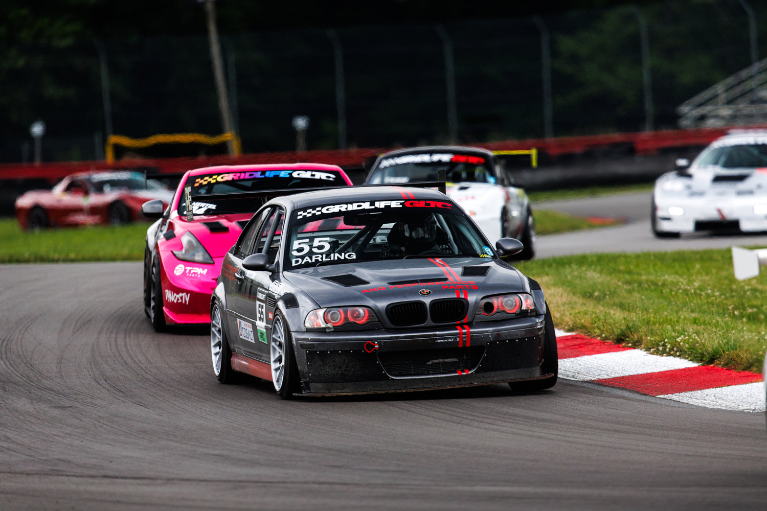A gray BMW E46 M3 race car on track with AKG bushings, motor mounts and performance parts installed.
