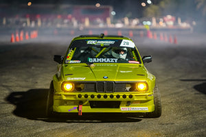 A green BMW E30 wide-body drift car with AKG performance parts.