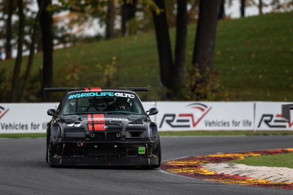 A black BMW E36 M3 at Road America with AKG motor mounts and bushings.