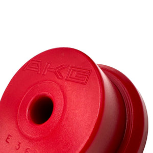Close up of red polyurethane 75D subframe bushings for BMW E36. Made in USA by AKG Motorsport.