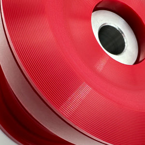 Close up of red polyurethane 75D rear subframe bushings for BMW E46, Z4. Made in USA by AKG Motorsport.