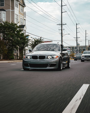 A city roller picture of a silver BMW E82 with AKG performance parts.